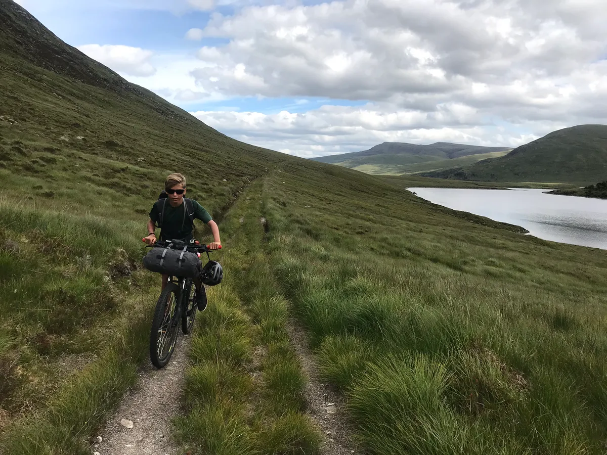 Billy pedalling up towards the watershed above Loch Choire