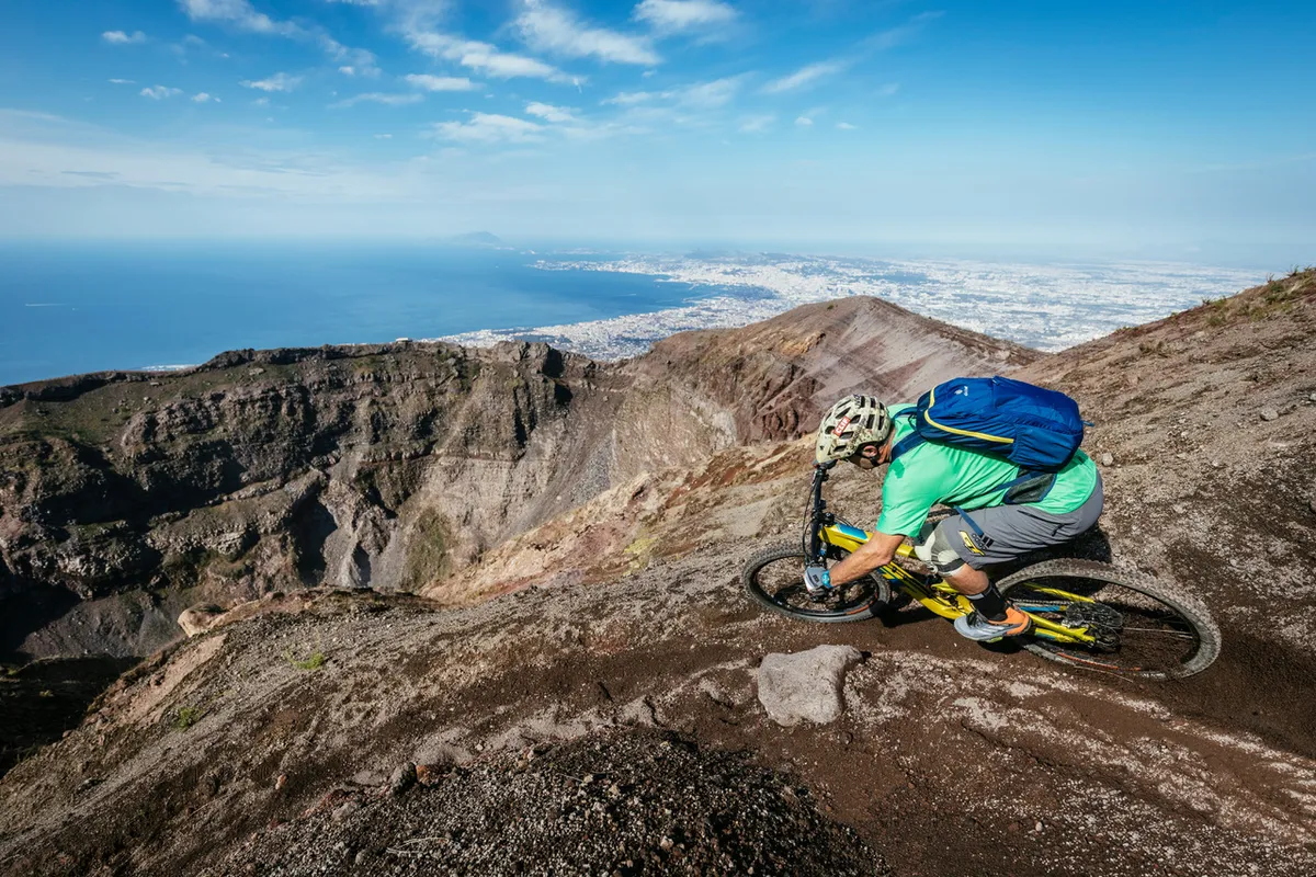 Don't look down! Hans rails around the lip of the giant crater on the still active volcano – Mount Vesuvius. The ancient Roman city of Pompeii is visible in the background, which was obliterated by an eruption in AD 79. Photo: Martin Bissig