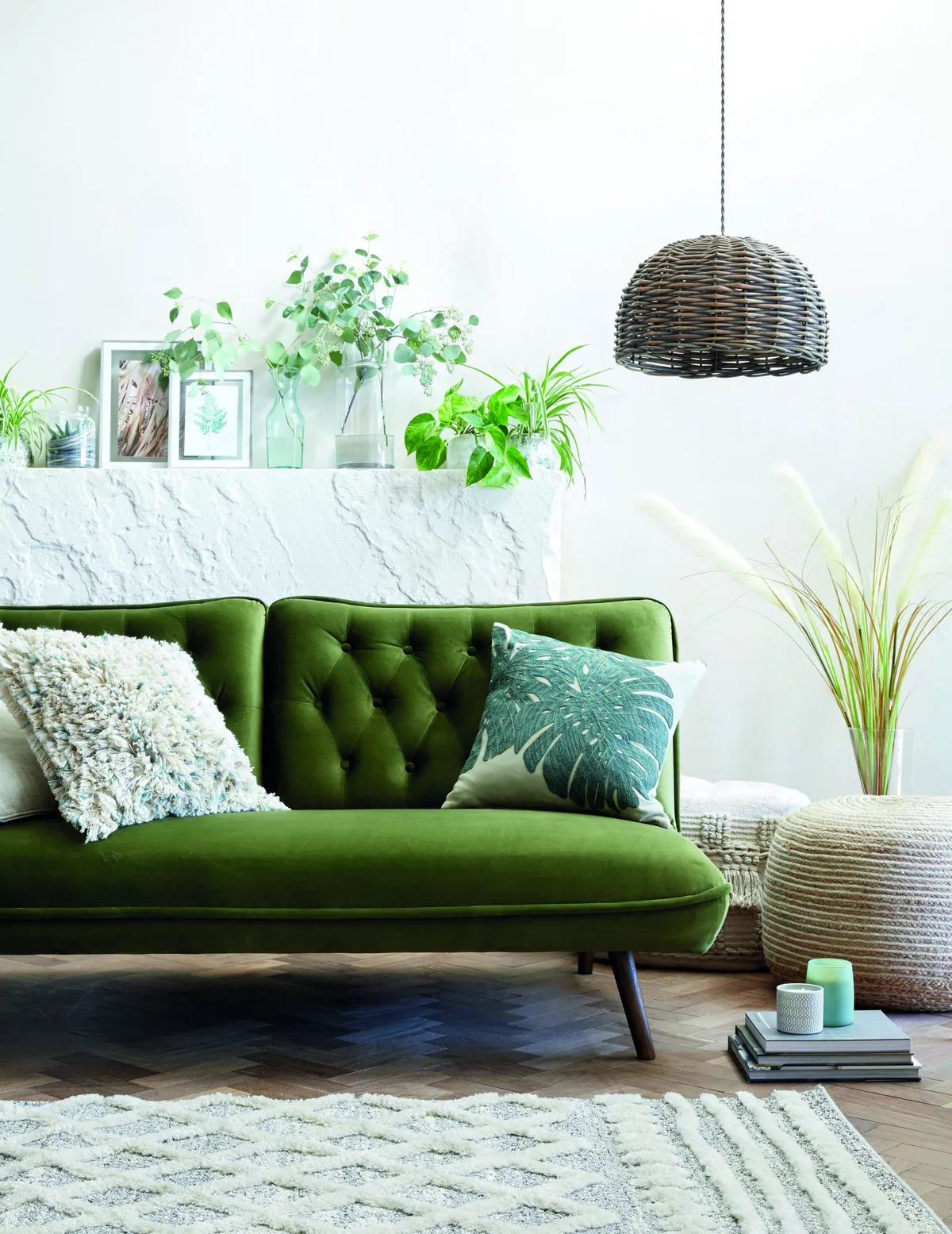 Elodie velvet sofa bed, £299; Ava pebble cushion, £18; Taza rug, from £55; Sanctuary cheese plant cushion, £22; Pampas grass stem, £5.50; Lari wicker weave easy-fit pendant, £29, all Dunelm