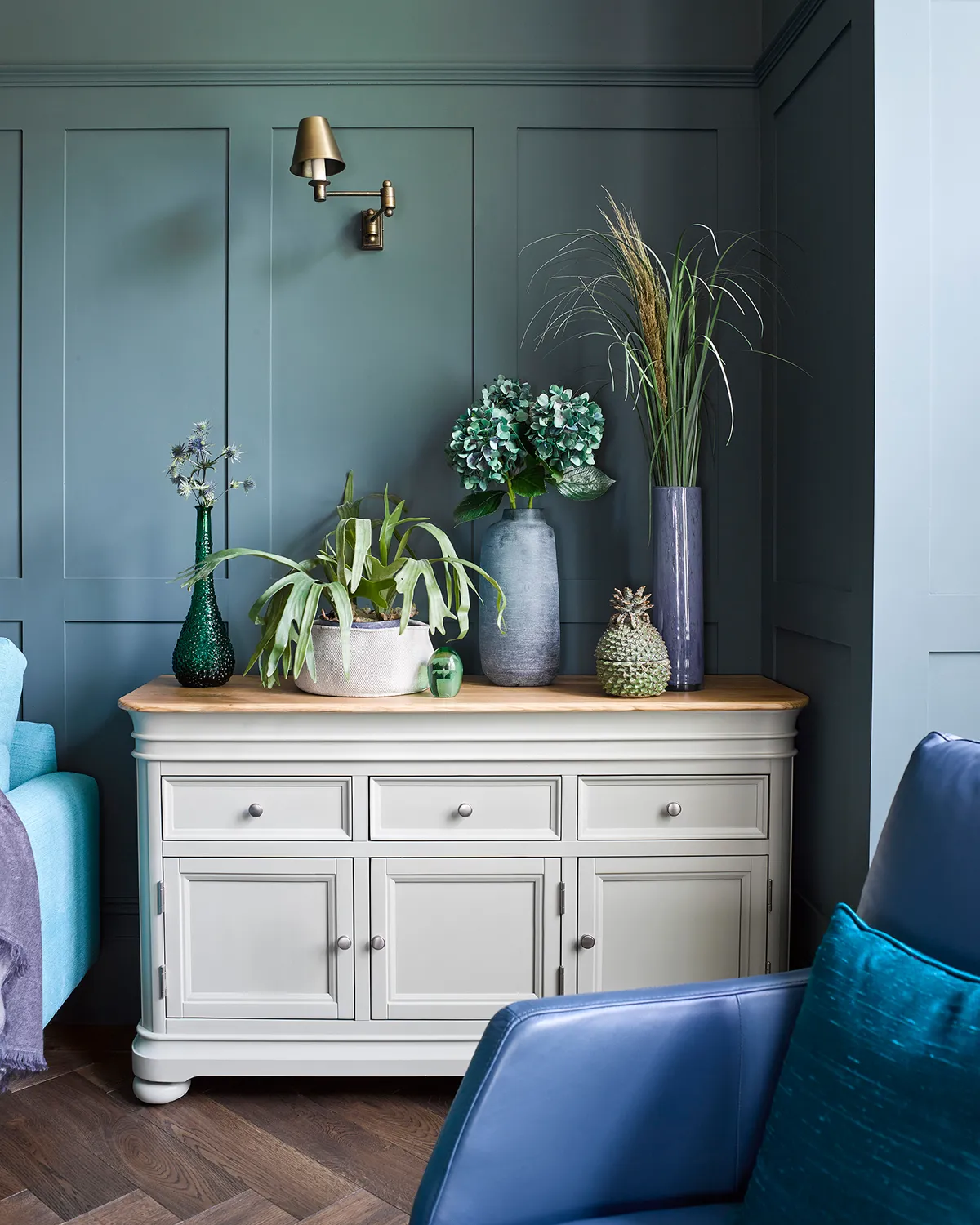 Cream, shaker style cabinets give blue panelled walls a cosy cottage edge. Image by Oak Furnitureland. 
