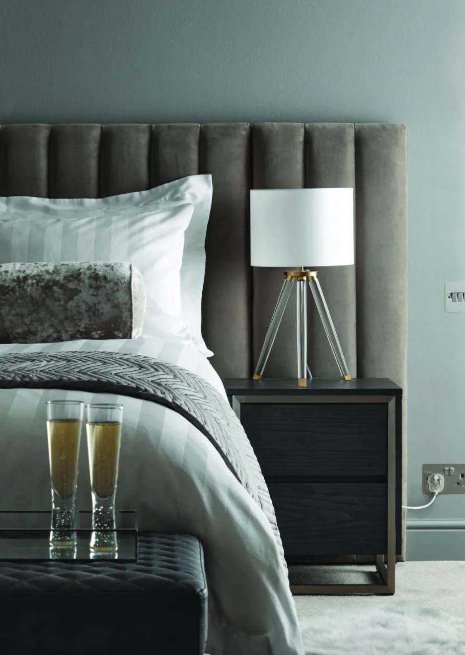 Fluted finishes are forever associated with art deco glamour, instantly creating a luxurious look in your home Oversized Hotel headboard, from £199; Hotel Finley tripod table lamp in silver, £45; Logan bedside table, £169; Hotel Egyptian cotton silver stripe duvet cover, from £25; Hotel Bubble stem flute glasses, £18 for a set of four, all Dunelm