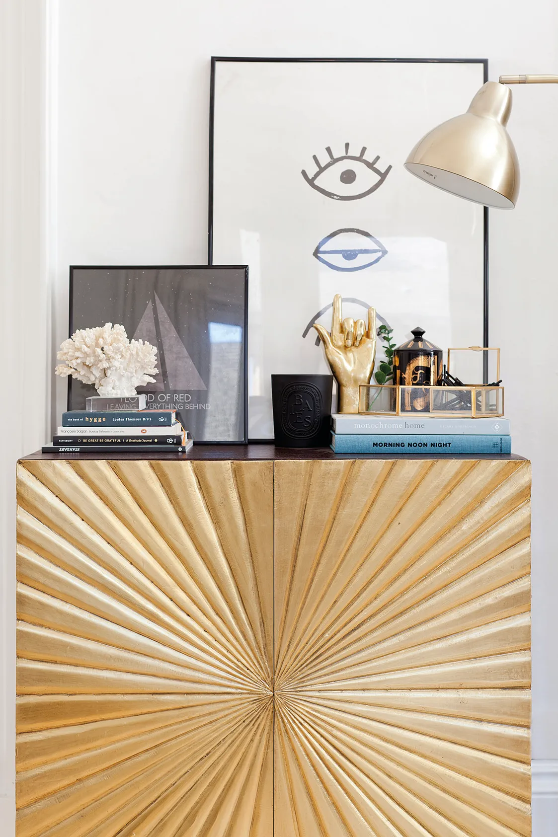 This striking gold and black sideboard from Swoon Editions gives the living room an instant shot of glam. Kate has styled it up with artwork from Society6, books and a collection of quirky accessories with gold and black accents to tie the look together