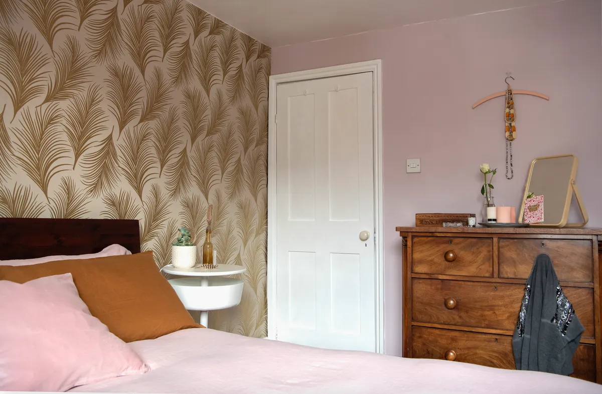 Real home - dusky pink bedroom with gold leaf wallpaper and a vintage chest of drawers
