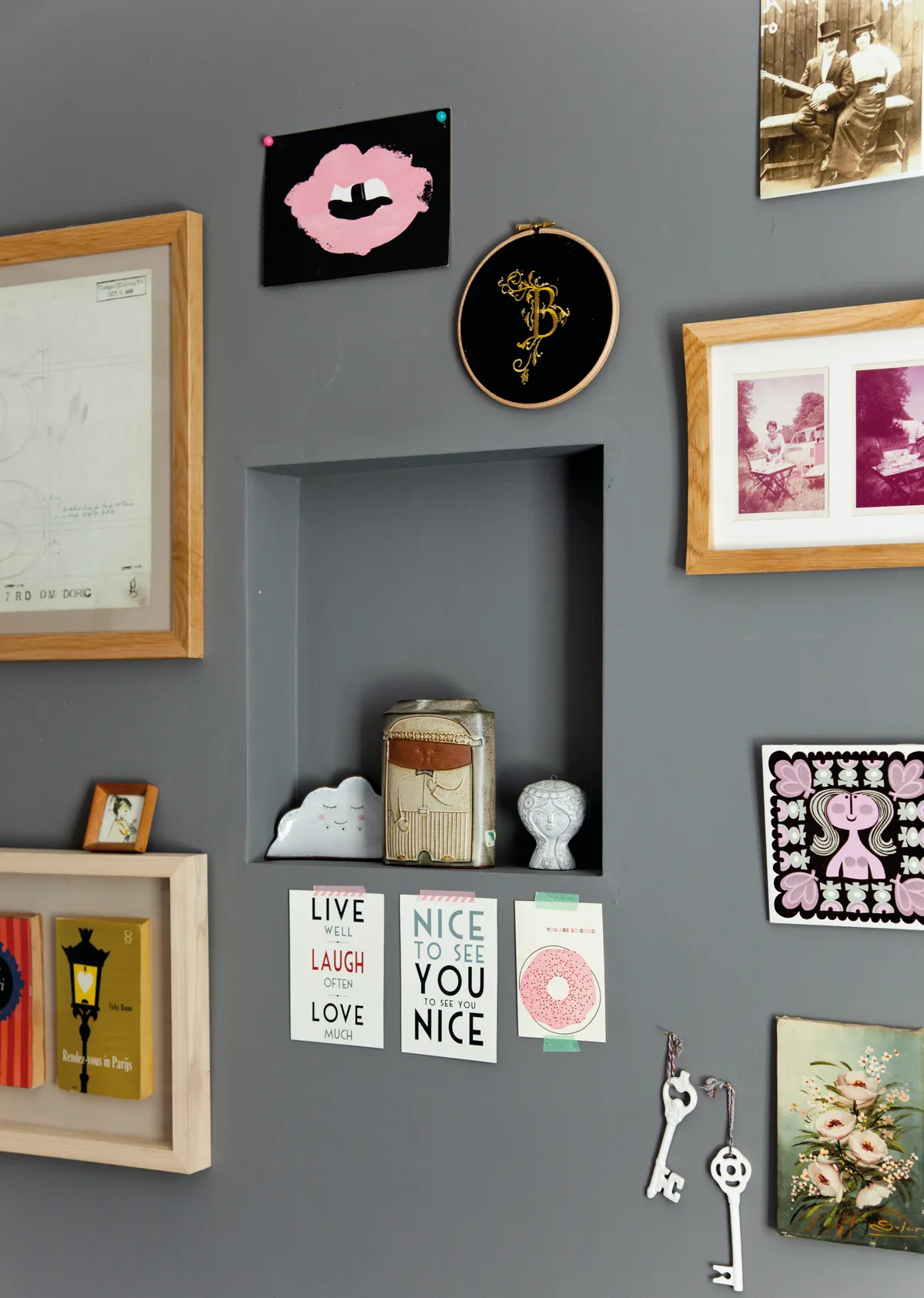 A grey wall displaying Christine's prints, photos, crafts and souvenirs