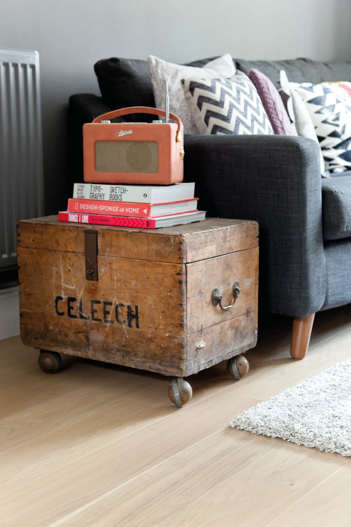 A vintage trunk with books and an orange digital radio on top