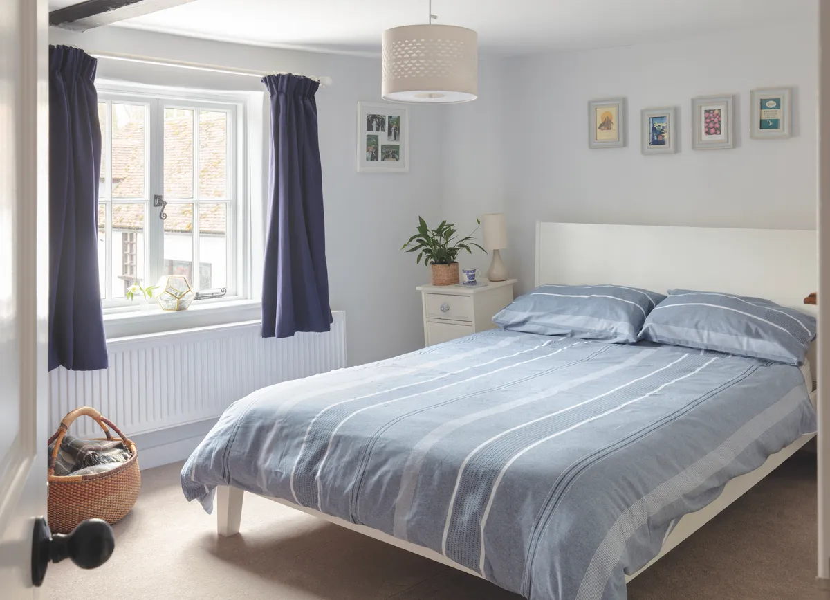 The spare bedroom doubles as an office and Sarah has toned down the colour in there but stuck to her favourite blues, with navy curtains from John Lewis & Partners and a subtle striped Willington duvet cover from Dunelm. See her home makeover.
