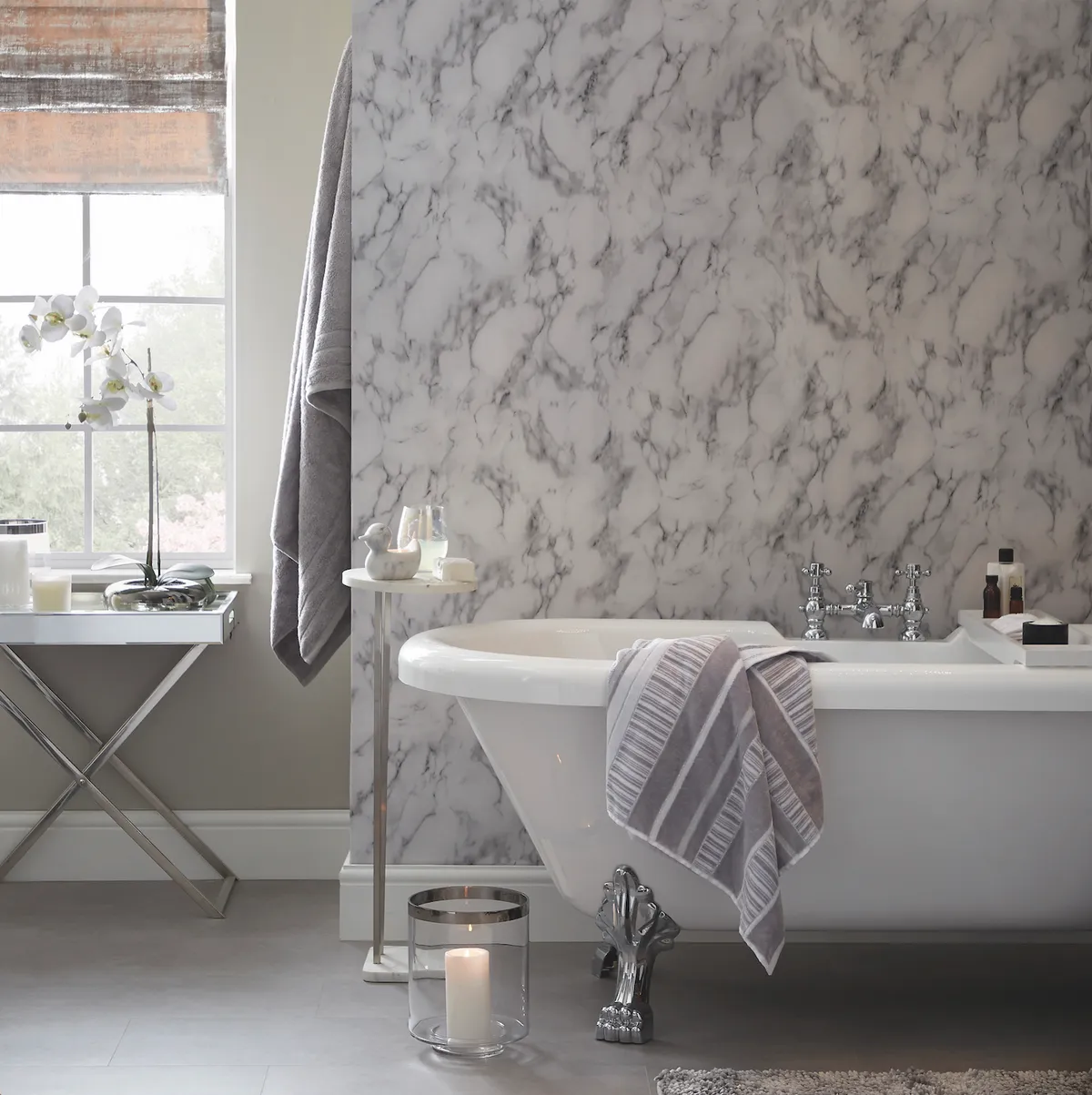 When the weather gets chilly and dark, a calm and therapeutic bathroom, like this one, which uses pieces from Dunelm’s Reluxed collection is just what you need. Romano silver Roman blind, from £30; Marble-effect top bath table, £35; Marble duck tealight holder, £5; Aura marble silver wallpaper, £10 per roll; Sheared stripe bath towel, £16; Glass cylinder vase, £12, all Dunelm