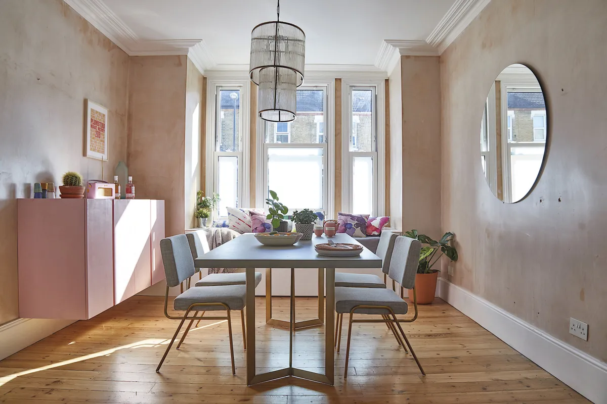 Sash-style windows flood the dining room with light, making it an ideal spot for morning coffee, while an oversized mirror on the wall reflects light back into the room
