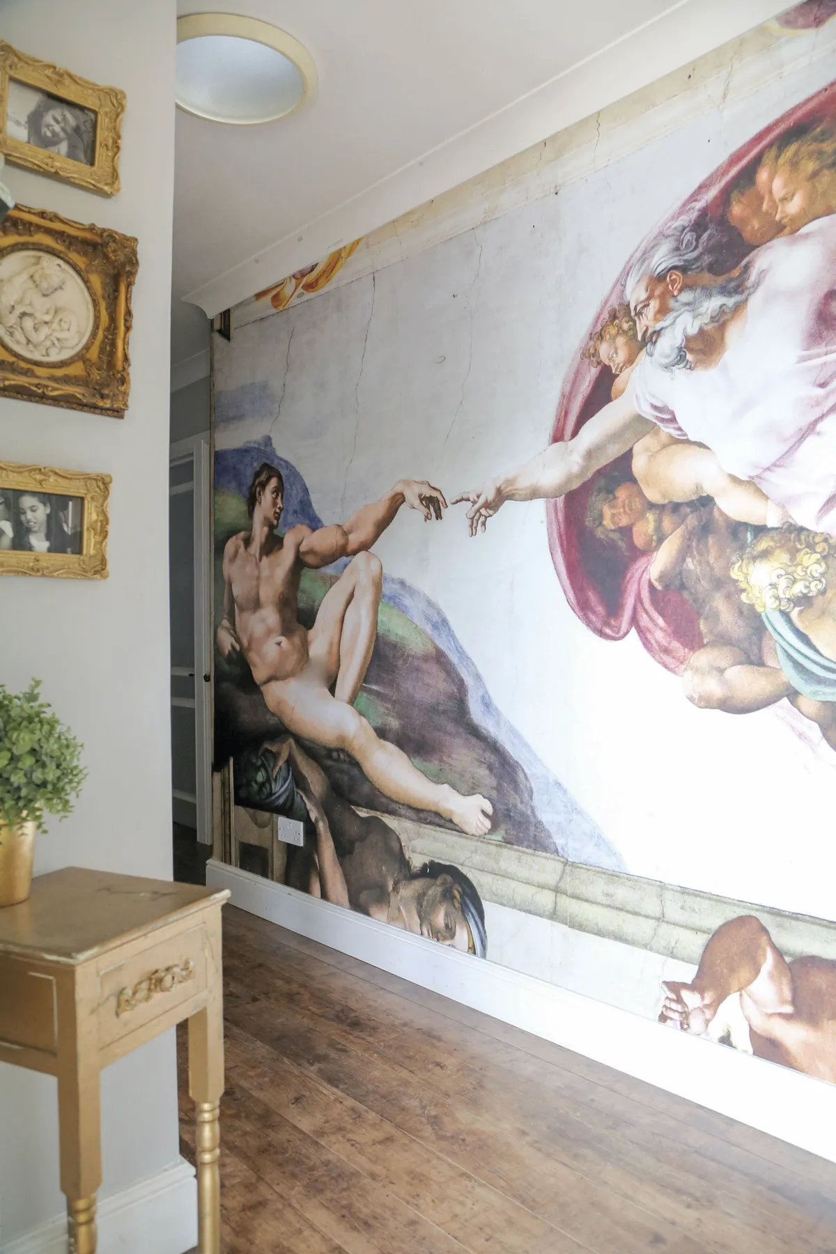 ‘I wanted the hallway to be an extension of the house and give guests a taste of my interior style the second they walk through the front door. I replaced the flooring with the same dark wood used throughout the house and painted the walls light grey. I hung an amazing mural depicting Michelangelo’s Sistine Chapel ceiling painting, and lots of framed photos of my family for a warm, friendly welcome’