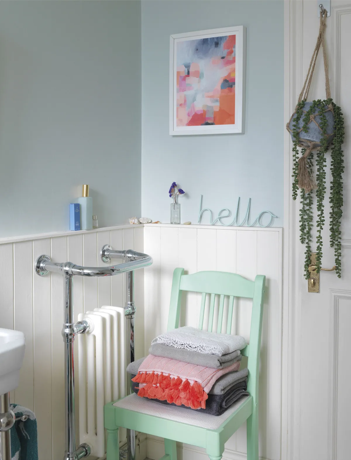 A quaint little chair sits in the corner of Emily’s bathroom. Painted in mint green, it’s another of her upcycling projects. ‘It makes an ideal spot for stacking the towels, only the pretty ones though!’ The colours reflect those of the artwork above, another one of Jessica Ford’s