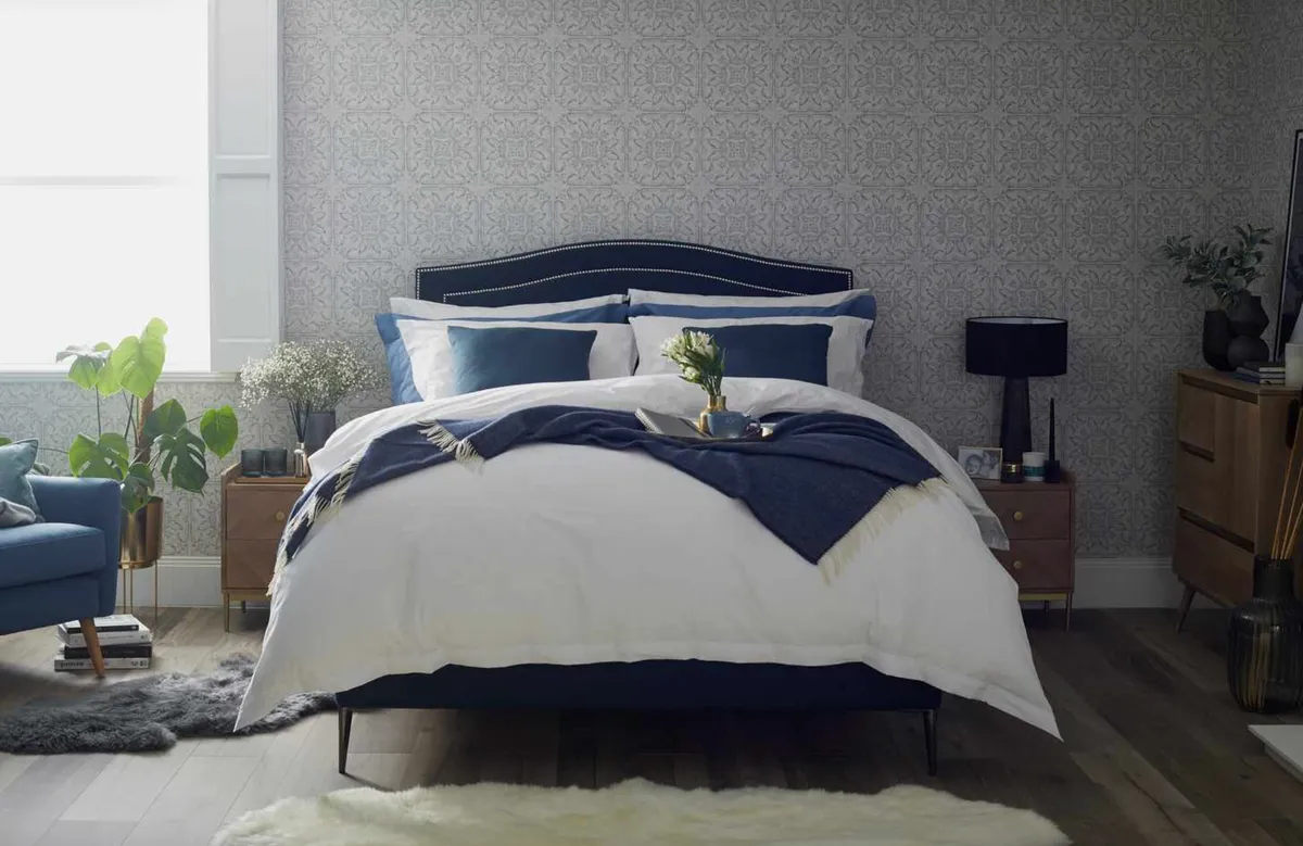 The Olivia upholstered bedstead, from £1,900; Deluxe washable wool pillows, £59.99; Deluxe all-season duvet, from £184; Lilly Herringbone wool throw in blue, £74.99; sheepskins, from £59, all from Woolroom