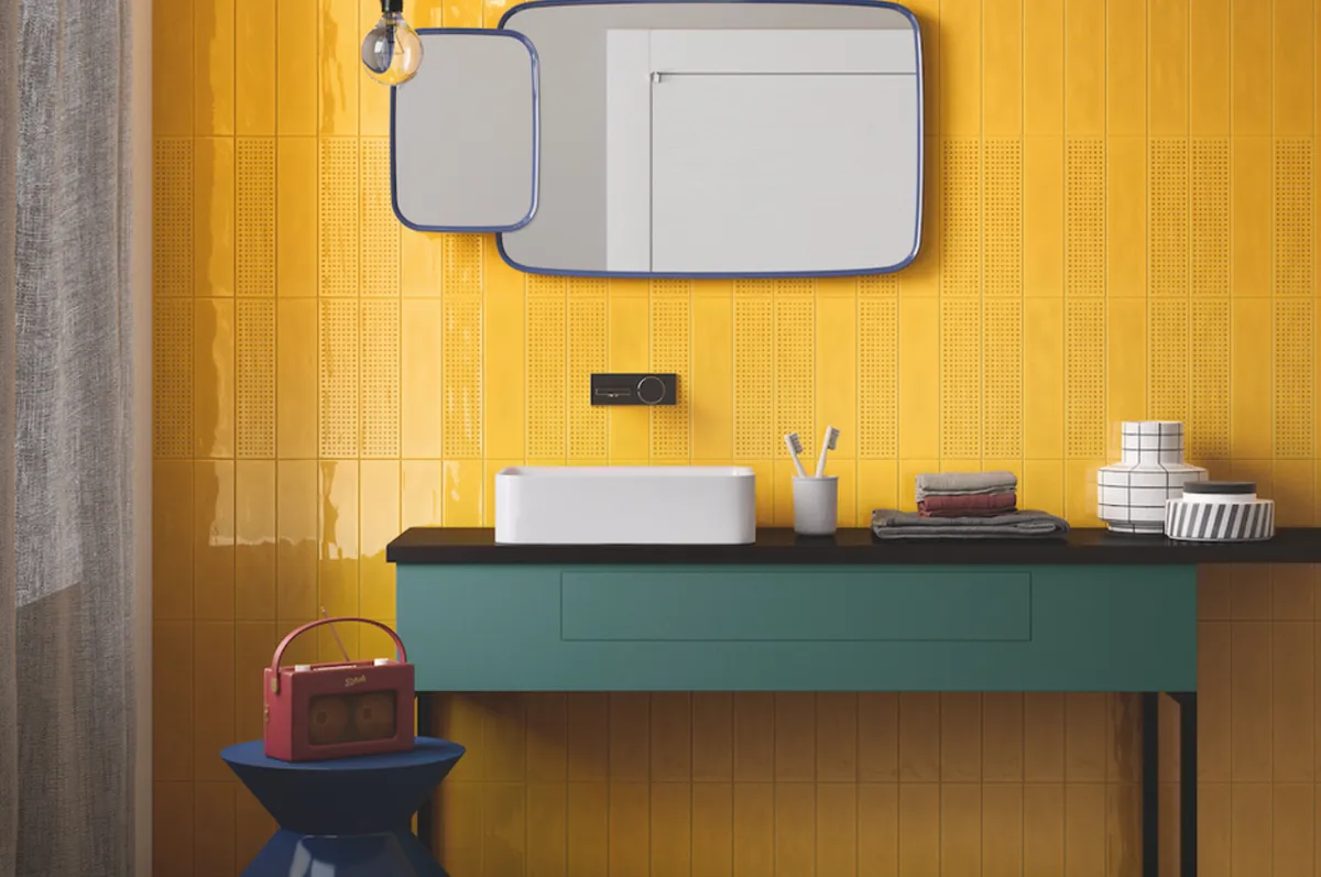 Colour-block with a bold feature wall of tiling – pictured here from the Salerno collection, £59.40 per sq. m, from Stone & Ceramic Warehouse – then choose bold tones in chunky shapes for retro contrast. Globe bulbs that hang low will also add to the vibe