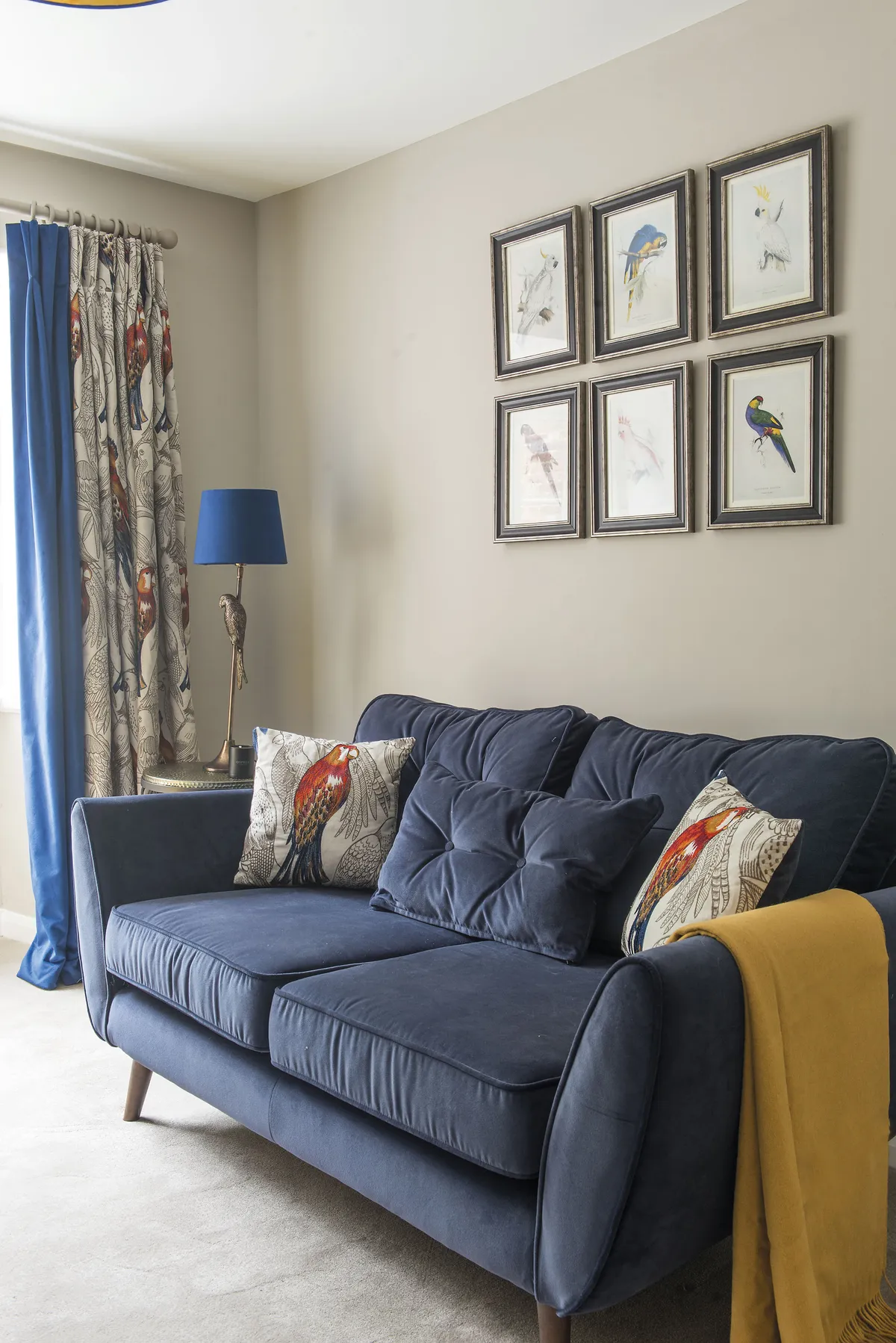 The couple decided on a Zinc blue velvet sofa from DFS for the snug and arranged their parrot prints above it. The wall is painted in Elephant’s Breath by Farrow & Ball