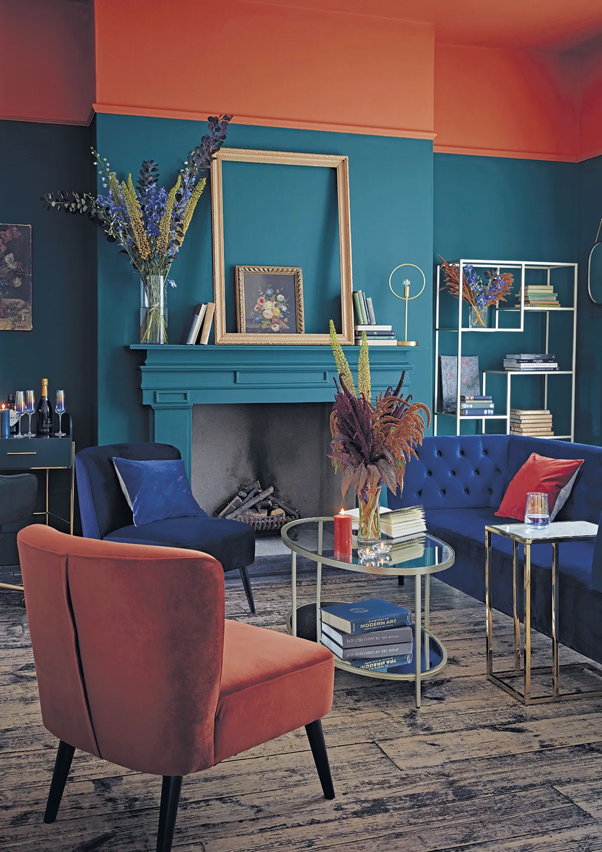 Chesterfield three-seater velvet sofa in blue, £500; Habitat Merlot velvet accent chair in orange and blue, £115 each; Dutch Glam glass coffee table, £250; Dutch Glam glass tall shelving, £350; Wilderness ring table lamp, £25; Dutch Glam boutique coffee table, £60, all Argos