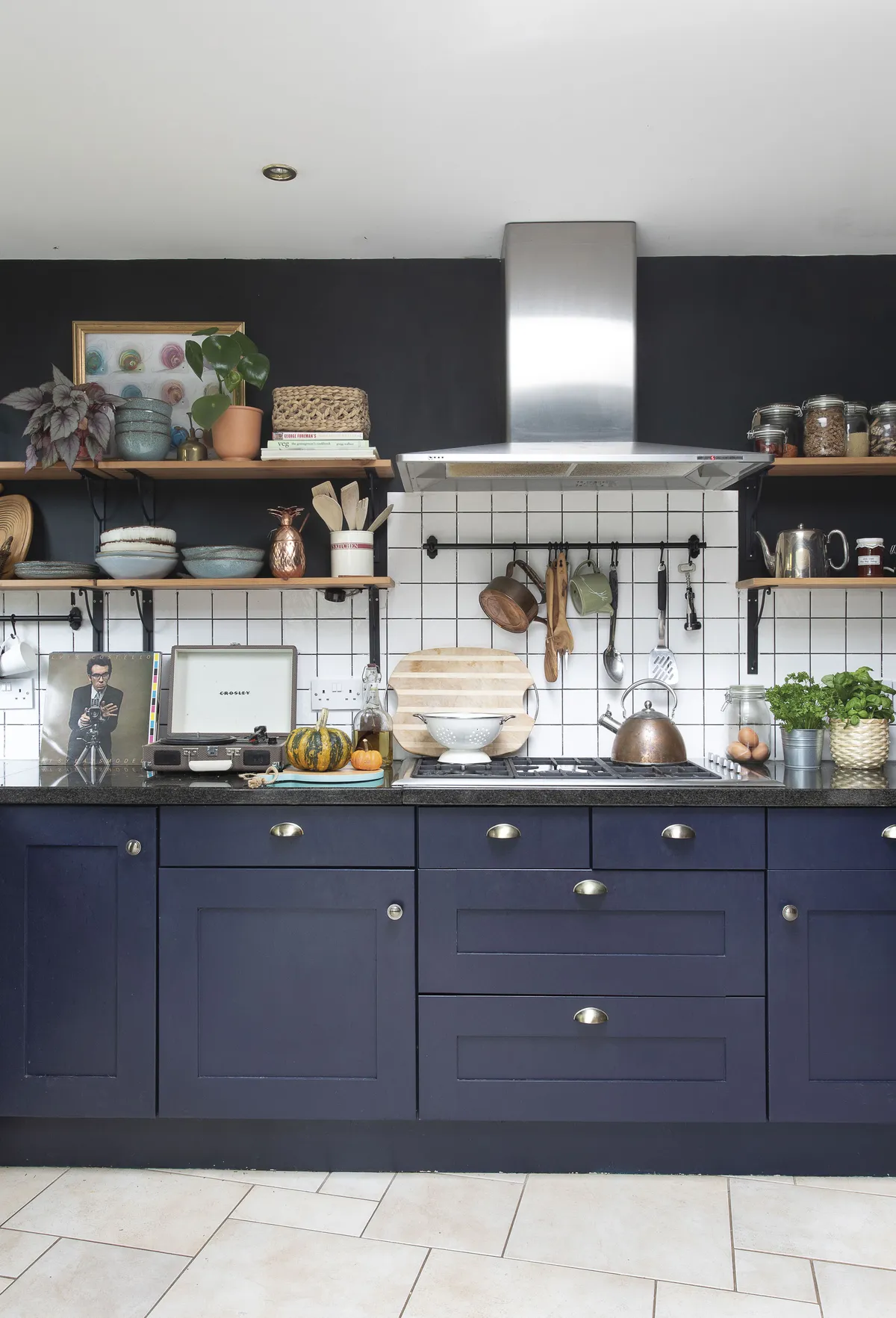 The cabinets were already here, and Eniko gave them a new look by painting them in Marine Blue by Little Greene. The dark brown walls are painted in Mole emulsion by Abigail Ahern. ‘I removed the wall cabinets and replaced them with open shelving. Blackboard walls are great for styling up Instagram moments!’