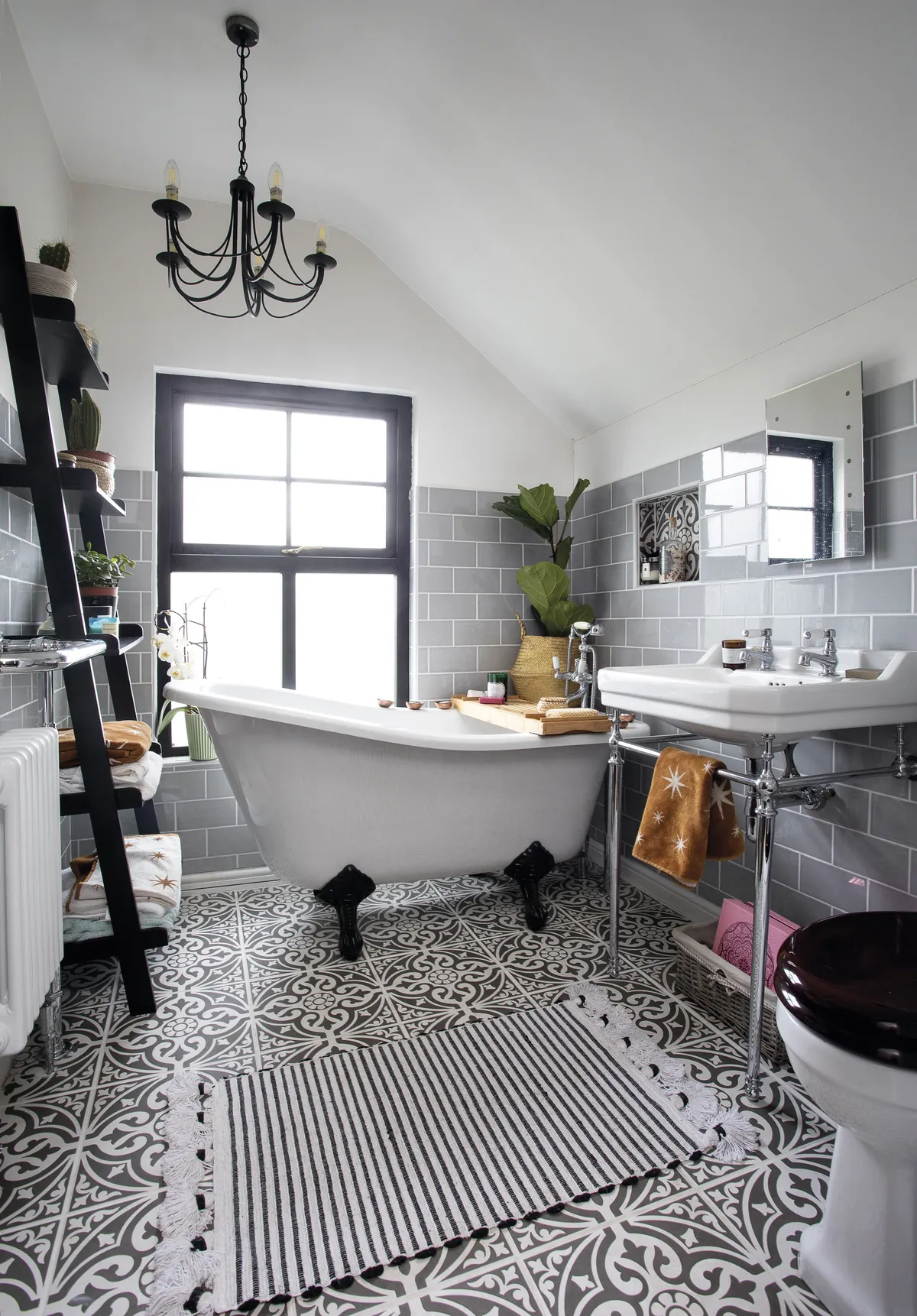 Eniko mixed modern and traditional in the bathroom, with Moroccan-style patterned tiles by British Ceramic Tile, a classic bath by Victoria Plum, and a ladder shelving unit from Amazon. The wooden bath rack is by The Wolf & The Fox, which specialises in sustainable products