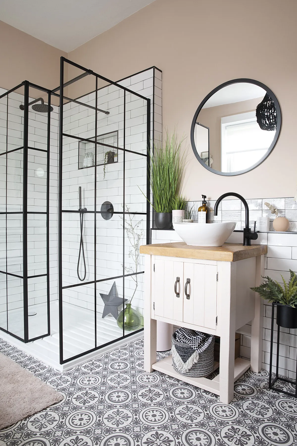 A false wall was built out so Liz could have an inset shelf in the shower and a ledge behind the sink for toiletries. The bold black beaded chandelier – just seen in the mirror – pulls the room’s scheme together