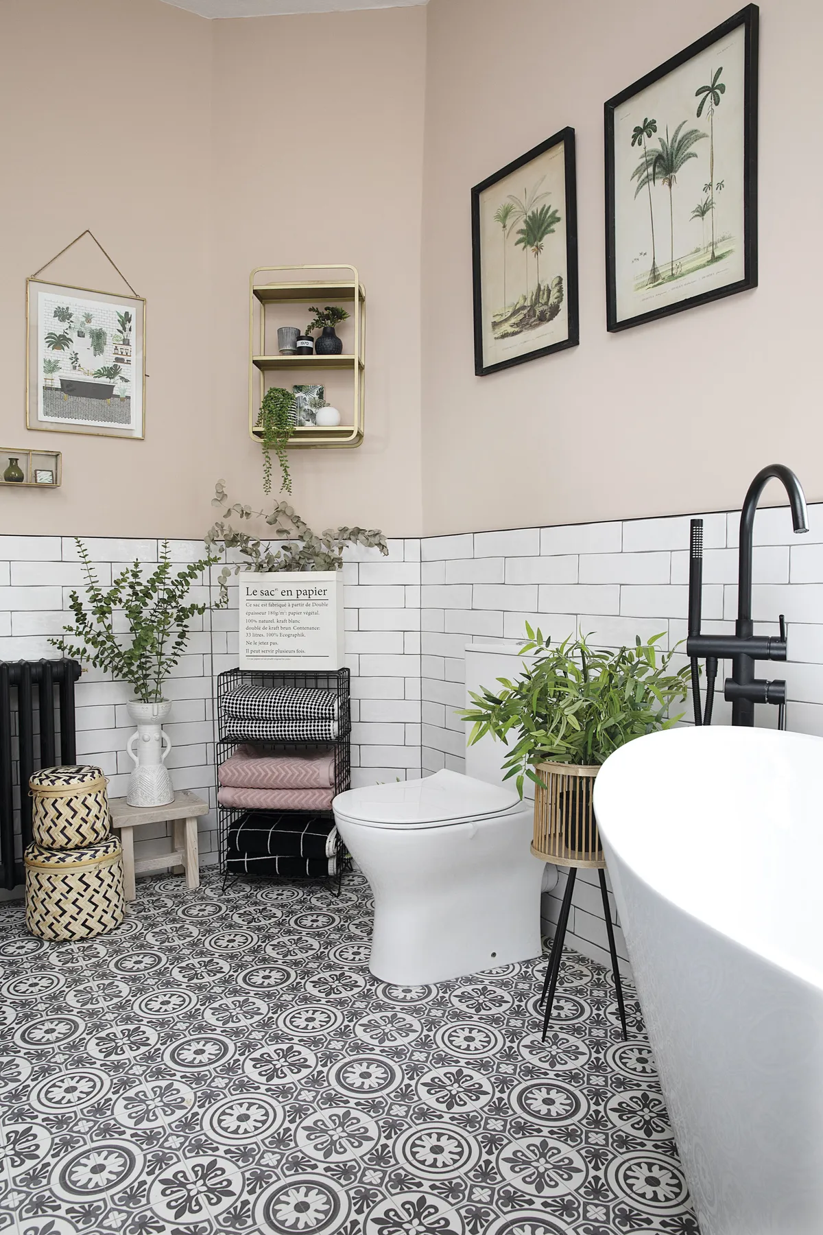 Although they toyed with putting the vanity unit in this angled corner, the couple felt it would work better on the opposite wall. Instead, they’ve moved the toilet further away from the bath and added a black mesh rack for storing towels