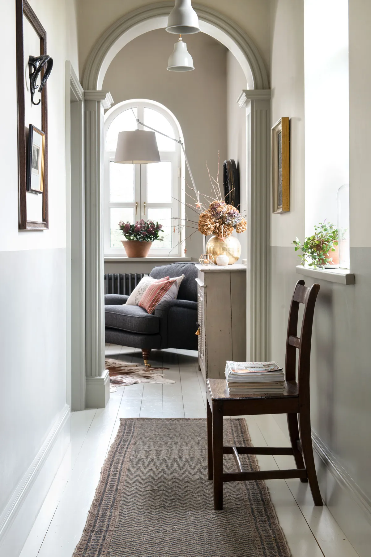 The chapel corridor was one of the features Kay loved the most. A row of pendant lights and framed art prints enhance the original detailing, and Kay painted half of the wall in a contrast shade for a faux panelled look