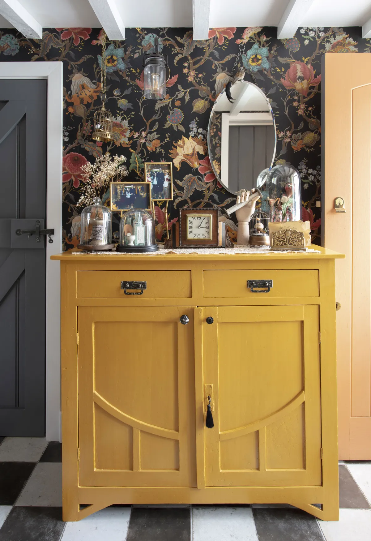 A vintage sideboard from an antiques fair has been renovated and painted a vibrant yellow hue picked out from the wallpaper, to provide a focal point and storage
