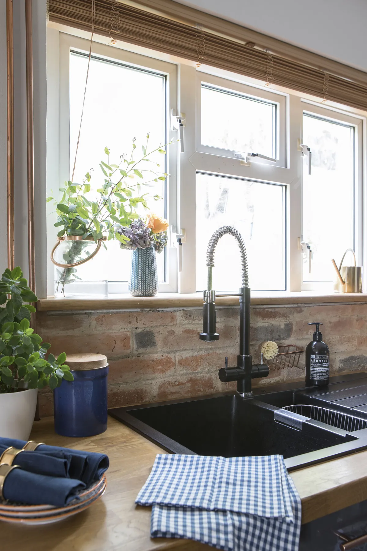 An easy-to-maintain black composite sink with a chunky hose tap is a functional choice for an industrial aesthetic. Dace moved the sink in front of the window to overlook the garden, a concept new to her that she’s grown to like since moving to the UK