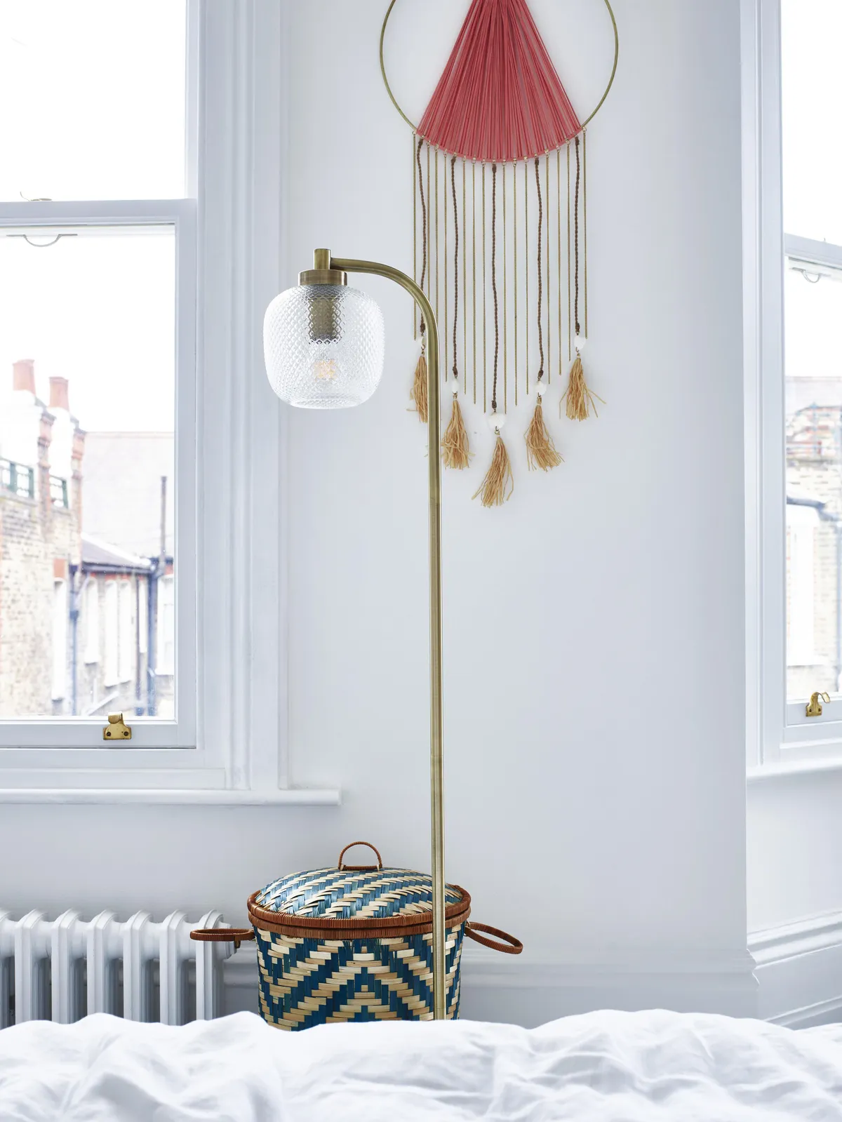 Round woven blue bamboo laundry basket, £45; Luce gold glass and marble floor lamp, £135, both Oliver Bonas