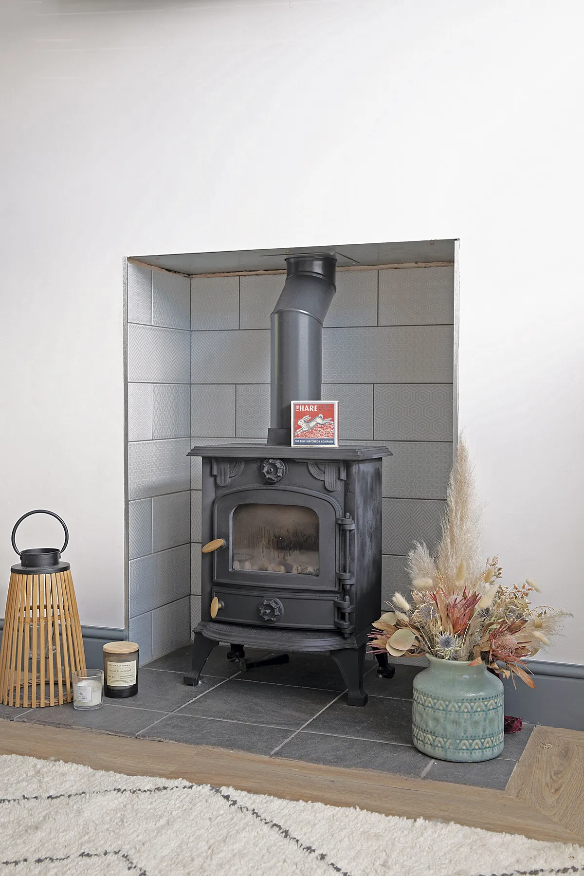 Buying a second-hand wood-burner from eBay has helped keep costs down, while simple flat matt white tiles behind make it stand out more