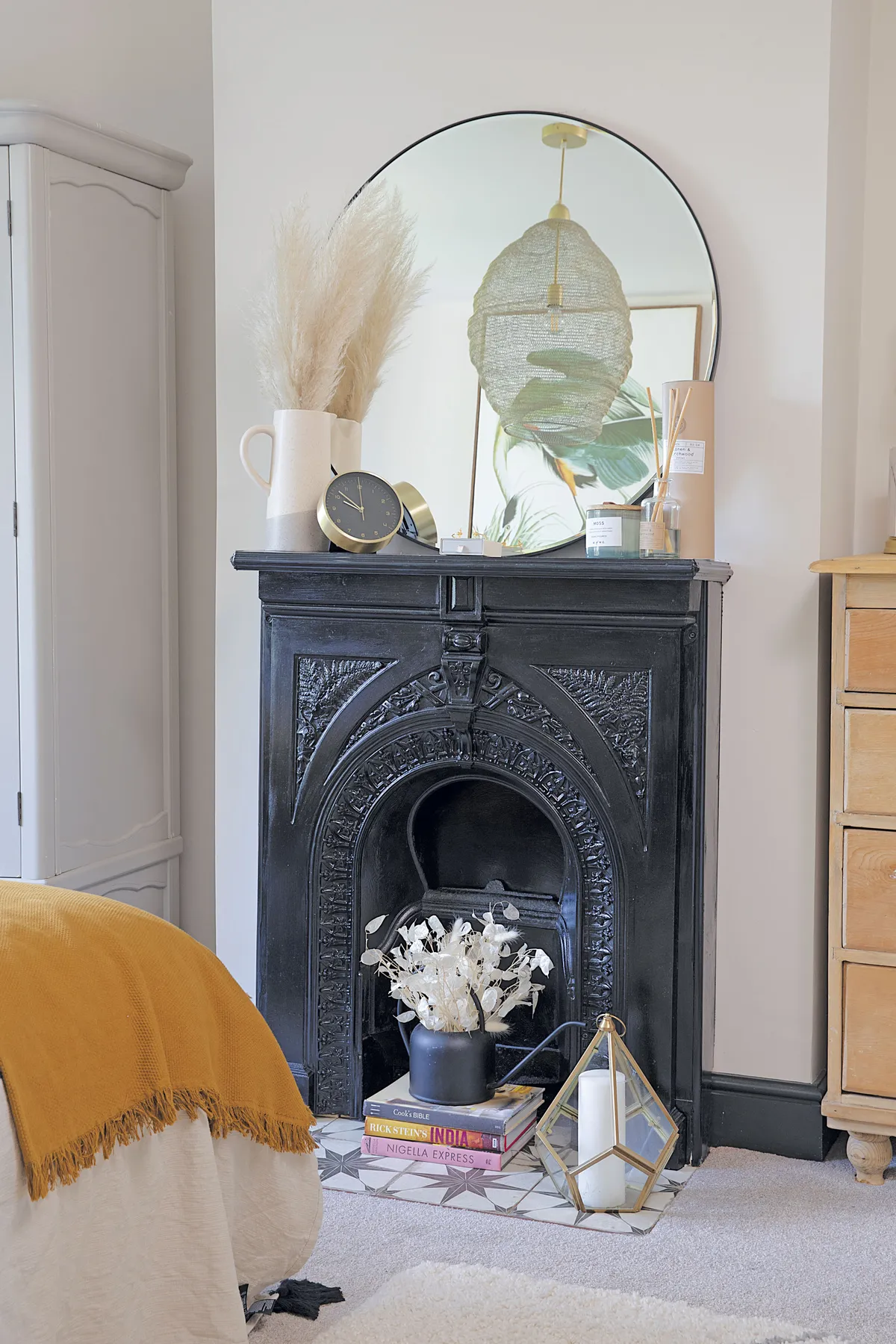 ‘We painted the reclaimed fireplace black for a more dramatic look and propped a mirror from Wayfair above,’ says Laura. ‘The wardrobe came from a furniture auction and I painted it pale grey when we moved here’