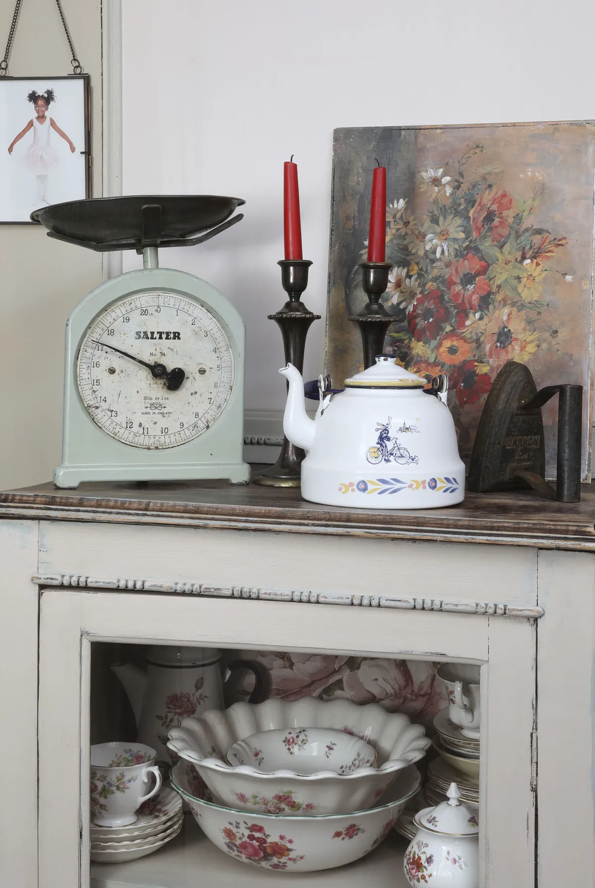 Sentimental pieces are dotted throughout the house. ‘The iron belonged to my late grandmother in Zimbabwe.’ The cabinet, from a local antiques shop, stores glassware, crockery and linens. Hildah has finished the display with a floral painting and cute enamel kettle from My Little Vintage