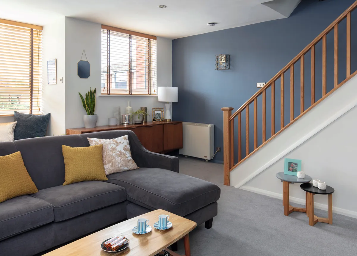 The wood tones of the sideboard and bannister bring warmth and contrast to Lynn’s smoky blue wall