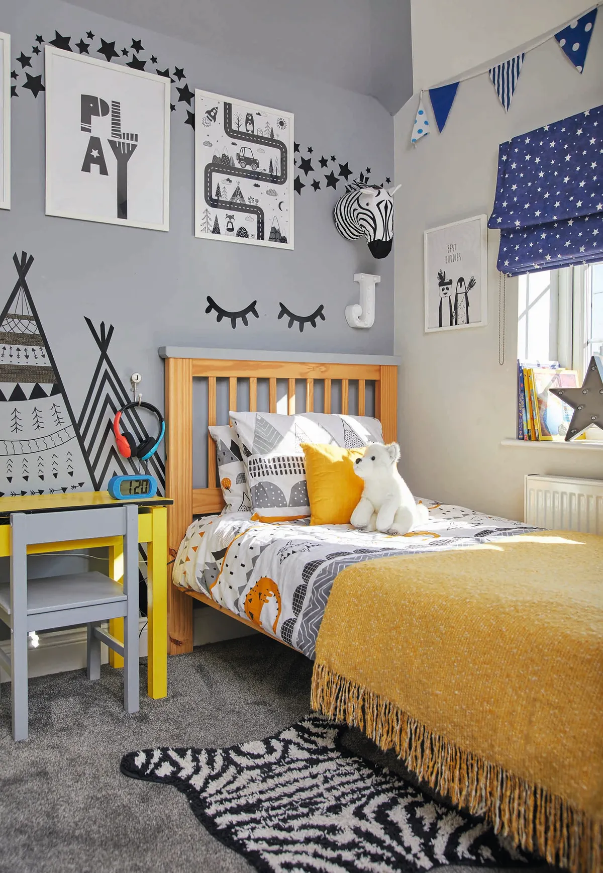 This kid's room has a yellow, blue and grey colour palette with prints on the wall from IKEA