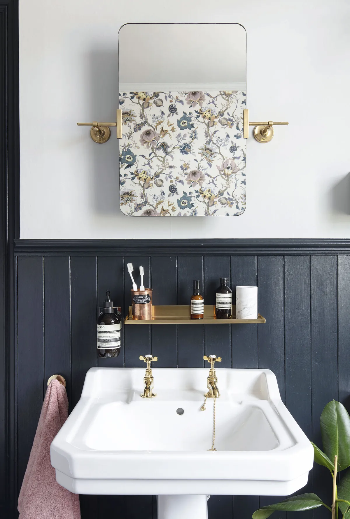 Emma has lifted her dark colour palette with pops of metallic, including these classic-look brushed brass taps. The floating shelf is a handy place for the couple’s toiletries and keeps the sink clutter-free