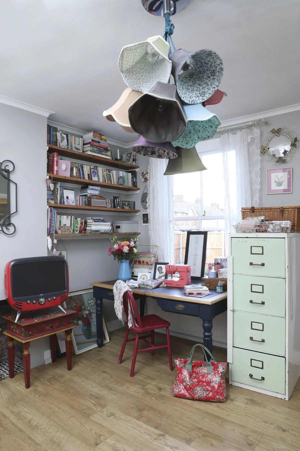 As well as working on her laptop, Hildah also enjoys crafting at her desk. The solid oak desk was from an antiques emporium, while the green filing cabinet was a charity shop buy. A lampshade chandelier adds a fun, colourful touch, fitting for a creative workspace