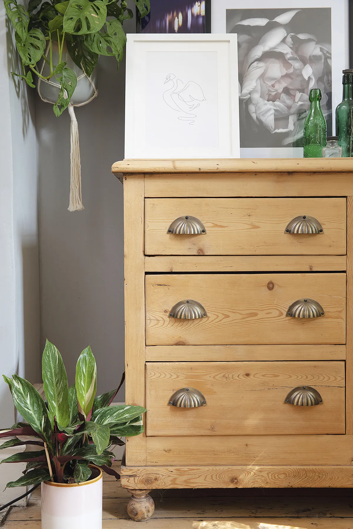 ‘This chest of drawers was so mucky it was nearly black, but I’ve given it a good sand and added new cup handles. The bottles were all dug out of my granddad’s garden and the prints are from Desenio’