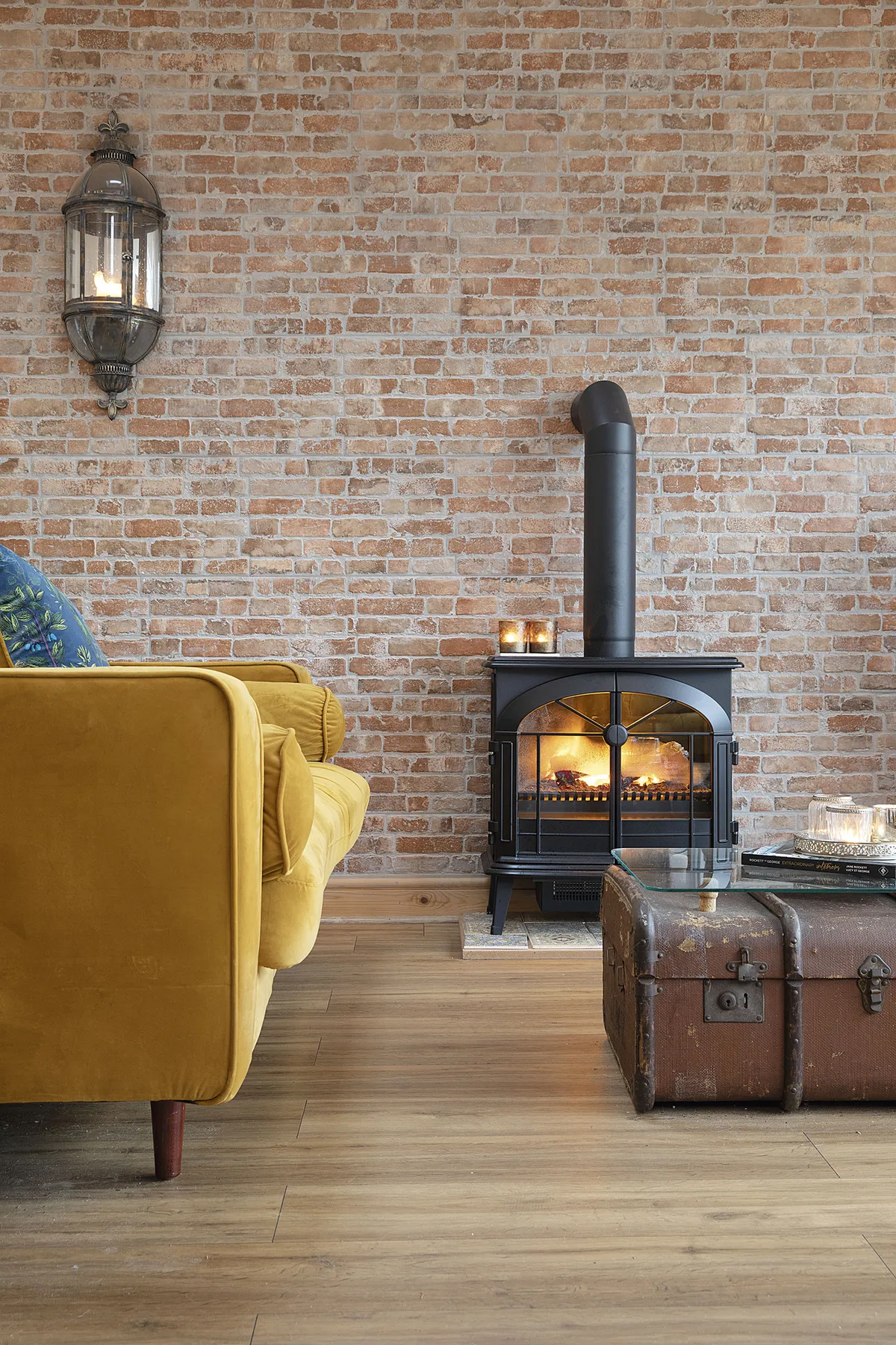 The faux brick wall is home to Sandra’s electric stove. ‘I put in a fake flue at the top to make it look like a real wood-burning one. It makes this space so cosy’