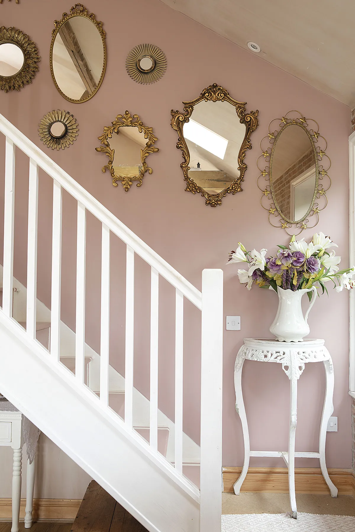 On the pink wall leading to the master bedroom, Sandra has hung a mixture of new and vintage mirrors. ‘The little round ones were £3.99 for a set of three from The Range. They were brown and I sprayed them gold to match the others,’ says Sandra. She painted the wall in pink chalk paint so her mirror collection would really pop