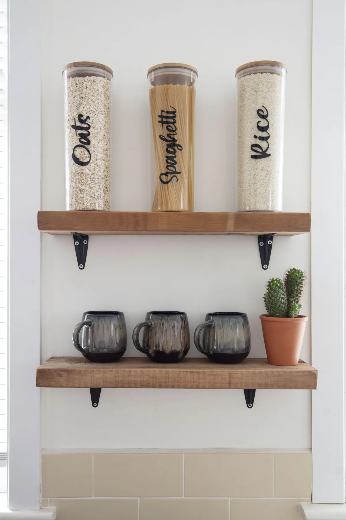 Although they’d like a new kitchen, Diandra has made the existing one their own with DIY touches. She fitted the shelves herself and decorated the jars with vinyl letters from Kady’s Creations