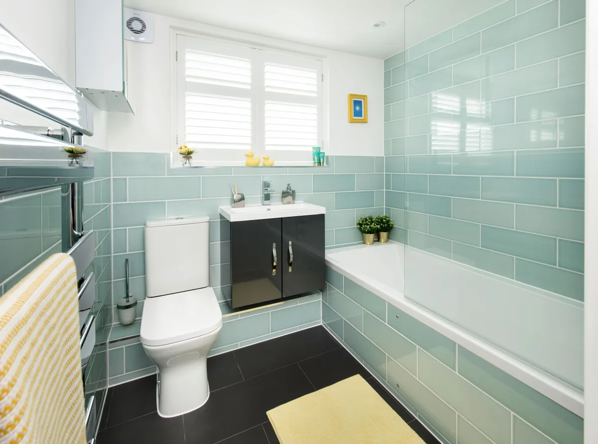 A simpler layout with a tiled bath and compact vanity unit and toilet has provided a fresher feel