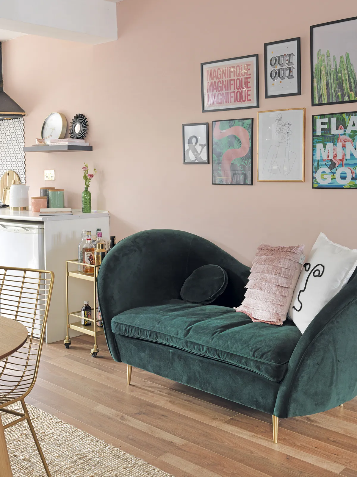 Opposite the dining table, a compact velvet sofa from MADE.com sits underneath a selection of fun framed prints and quotes. ‘I’ve gone for a dark green and blush pink scheme with gold and brass accents,’ says Raya. ‘The drinks trolley next to the sofa gets pulled out when friends are round, but it’s small enough not to get in the way’