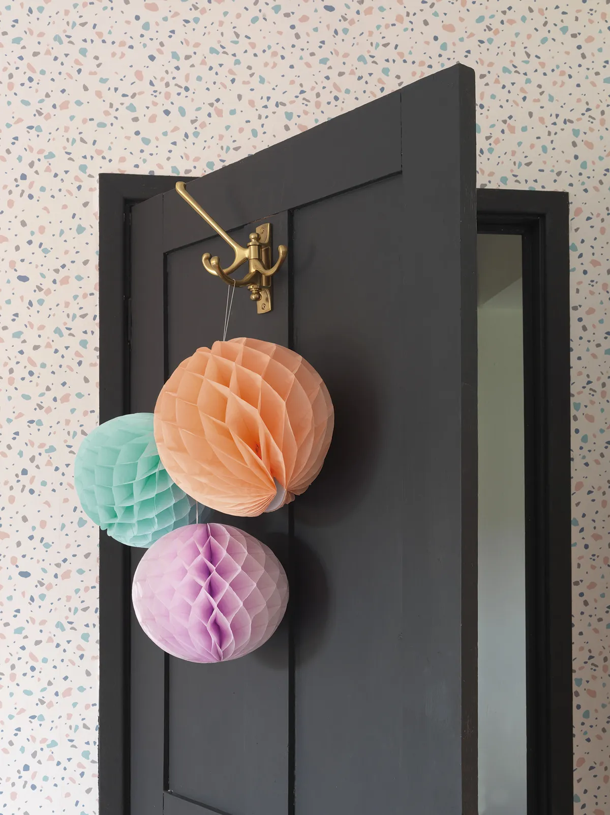 Raya already had the honeycomb paper decorations but realised they perfectly matched the colours in the B&Q terrazzo wallpaper. ‘I just thought, why not keep them up?’ she says