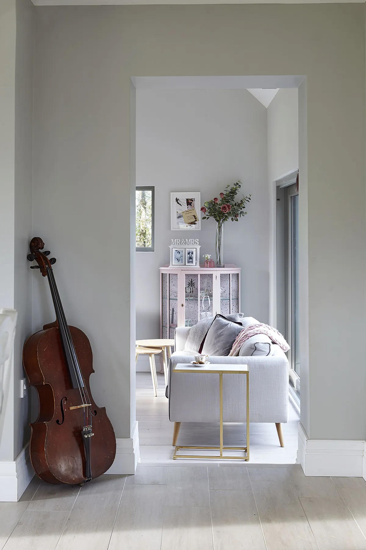 A vintage cello displayed alongside a sleek gold side table is a prime example of Gillian’s savvy mixing of styles