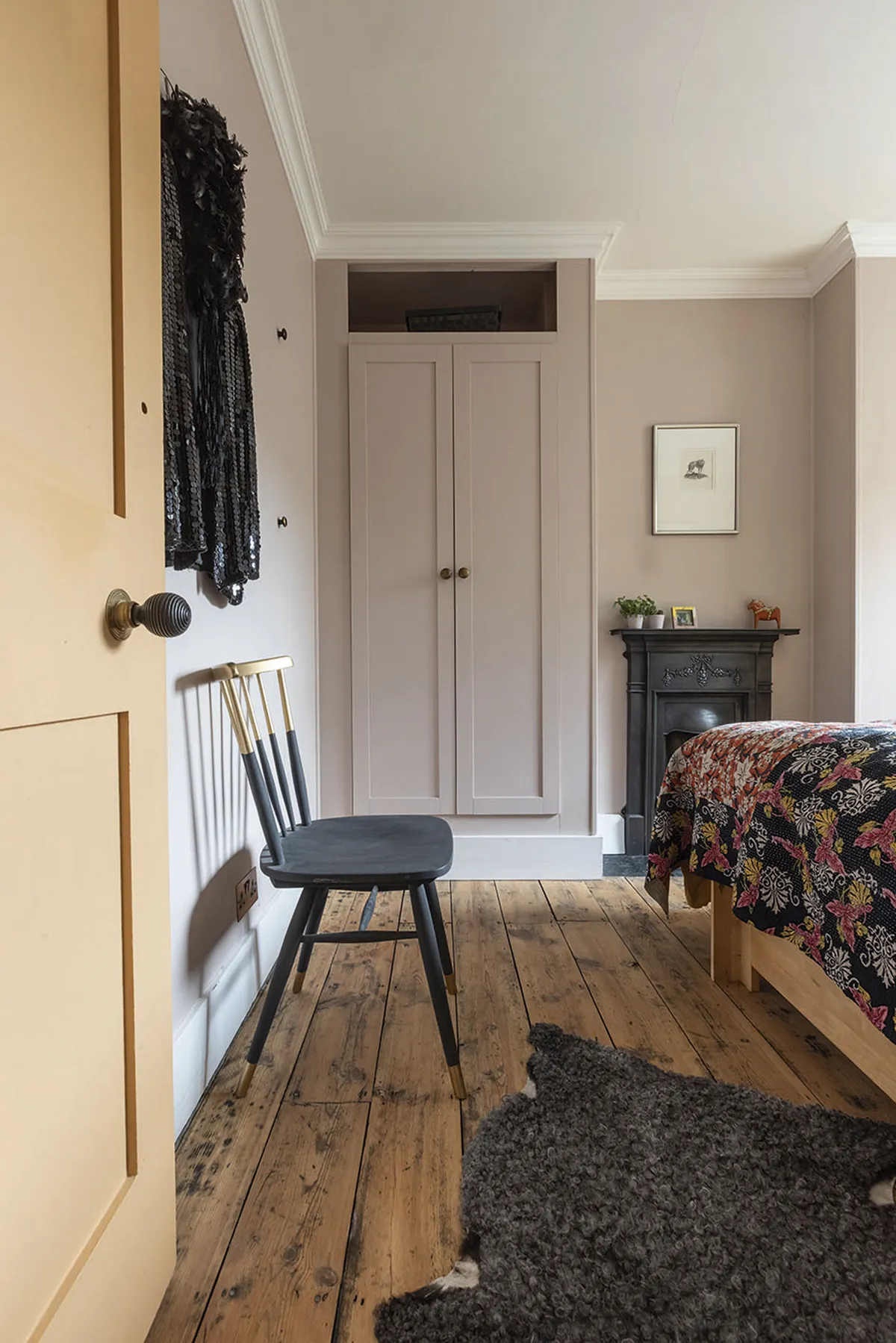 In the guest room, a colour scheme of mauve, black and grey draws the eye to the Victorian, cast iron fireplace. Carey and Johan designed the wardrobes themselves using IKEA doors, as in the main bedroom