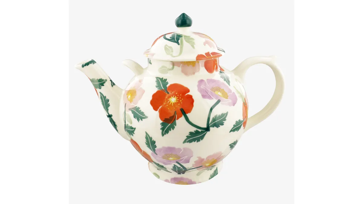 A large teapot with a poppy pattern on a white background.