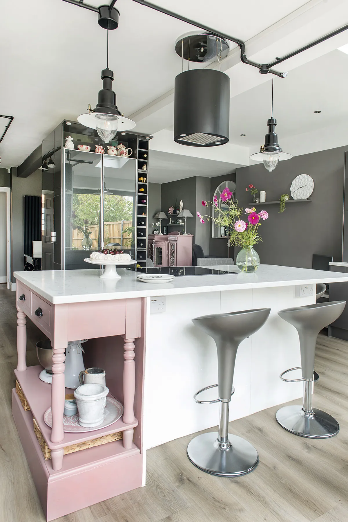 Sarah has softened her modern scheme with splashes of baby pink, including an upcycled console table, which she’s painted in Farrow & Ball’s Sulking Room Pink and built into the island unit, styled with Bombo stools from John Lewis