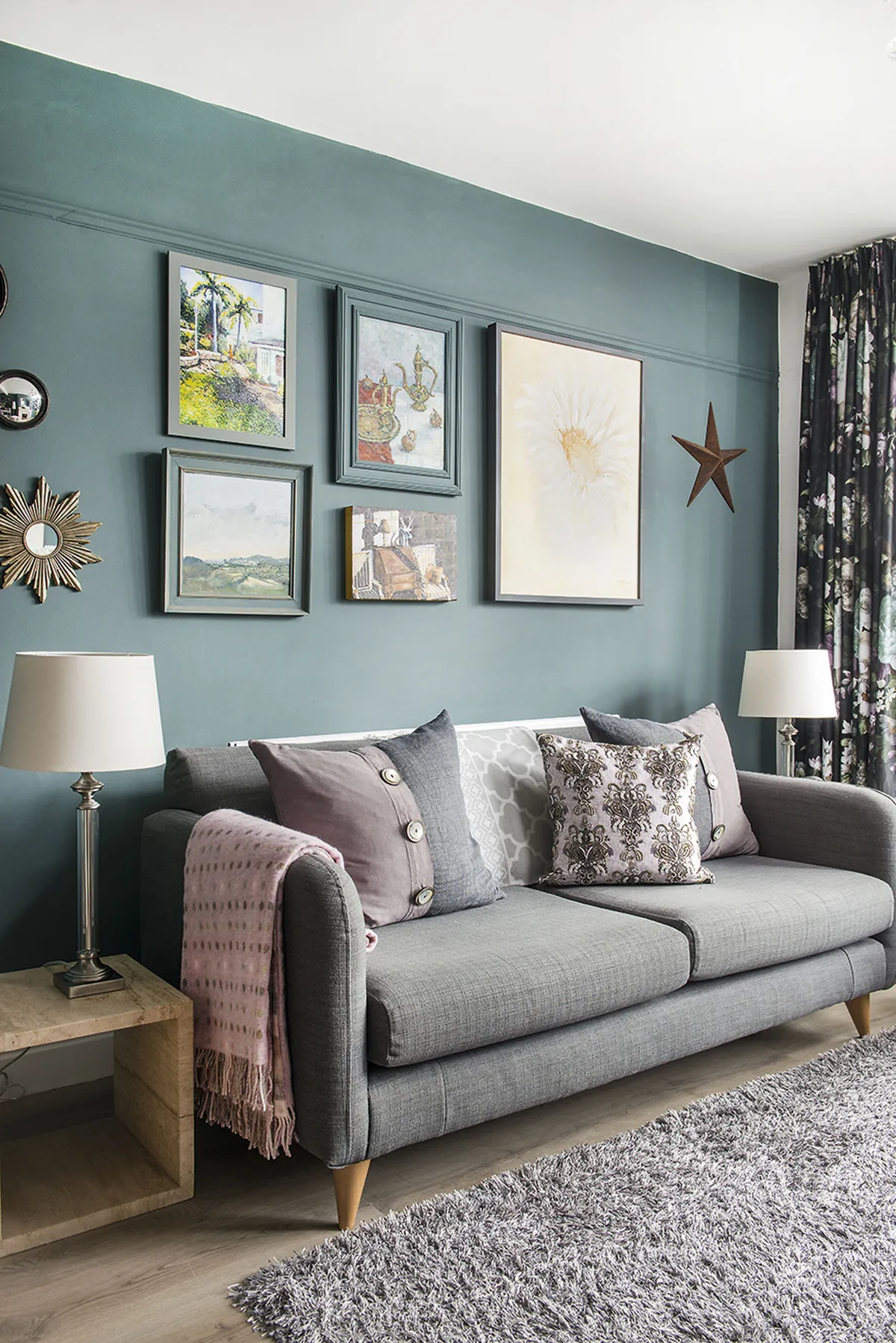 A gallery wall behind the sofa displays paintings by Sarah’s husband, Colin, along with the Moroccan Teapot by Clova Stuart-Hamilton. Accessories from Garden Barn Emporium and textiles in a mix of plains and prints add to the arty vibe