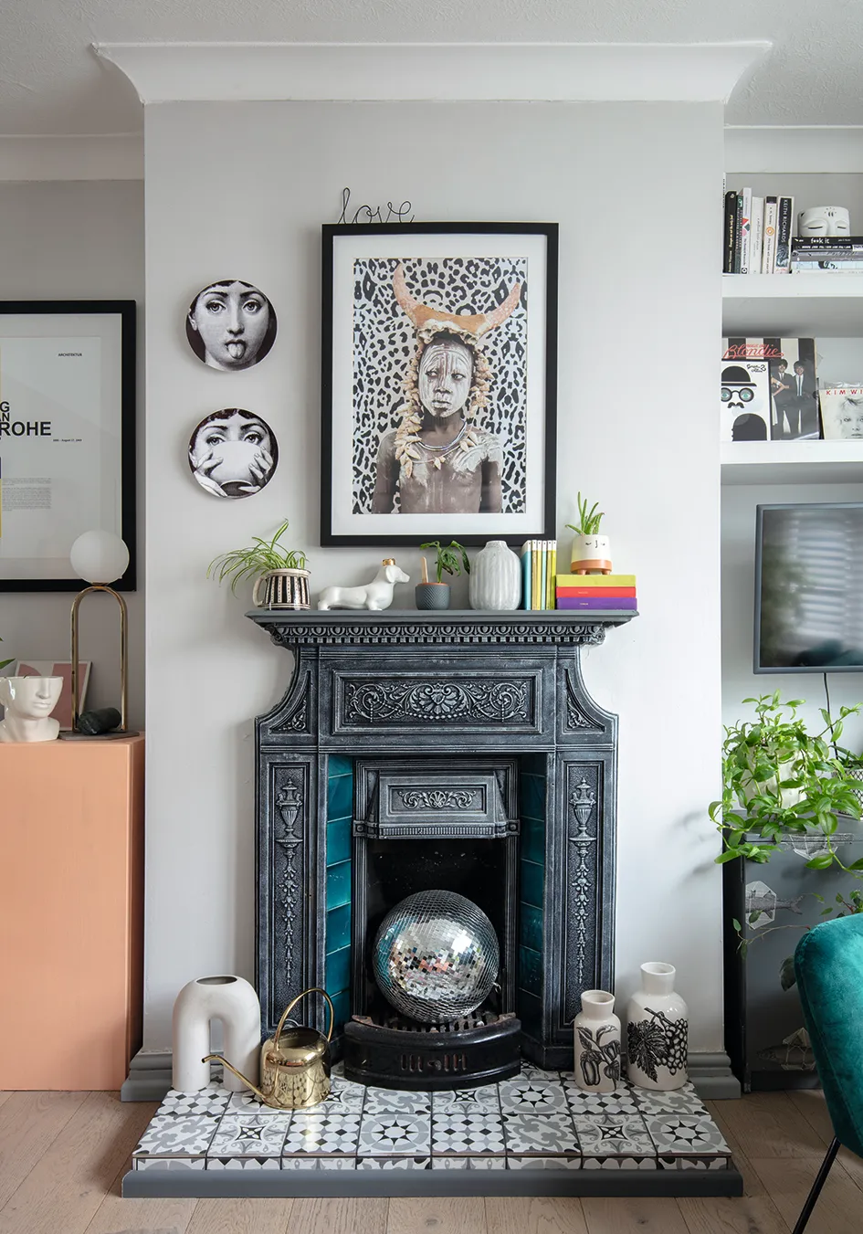 Although not original to the house, Maxine has kept the Victorian-style fireplace that she dusted with white paint to highlight the ironwork details. The artwork is by Lumitrix.