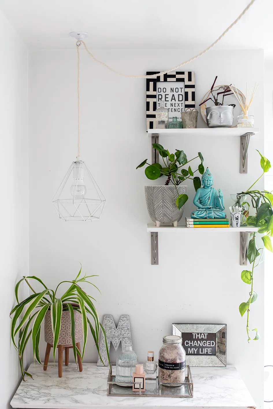 Wall shelves by Dowsing & Reynolds make for a pretty display space. Filled with plants, artwork, candles and accessories, they help to add character to the bathroom