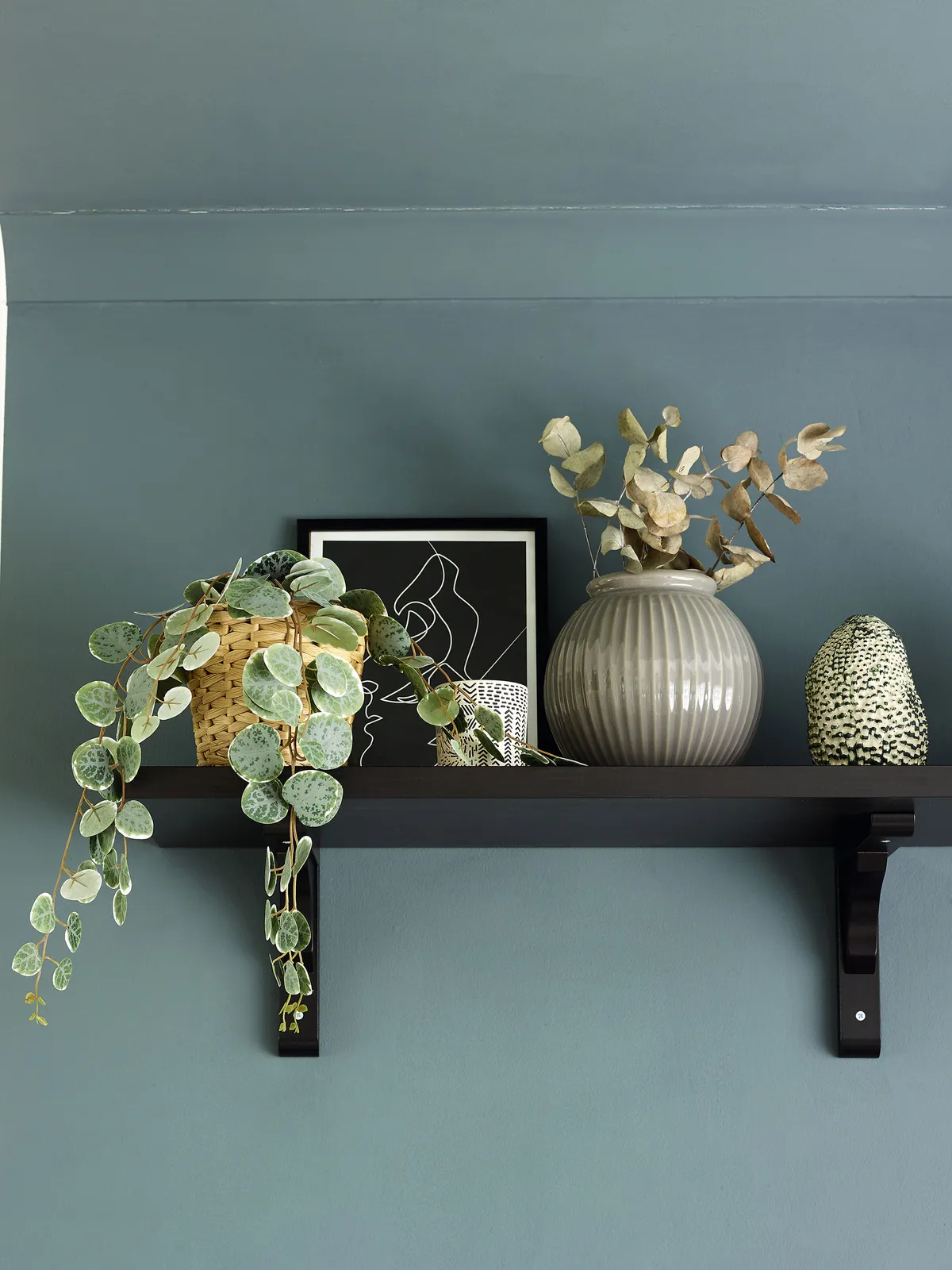 ‘Before starting, I planned out exactly what I wanted to do to this room,’ explains Nina. To draw attention to her teal colour-block centrepiece and tie in with the other dark accents, she added a black shelf with vases and a print from Desenio