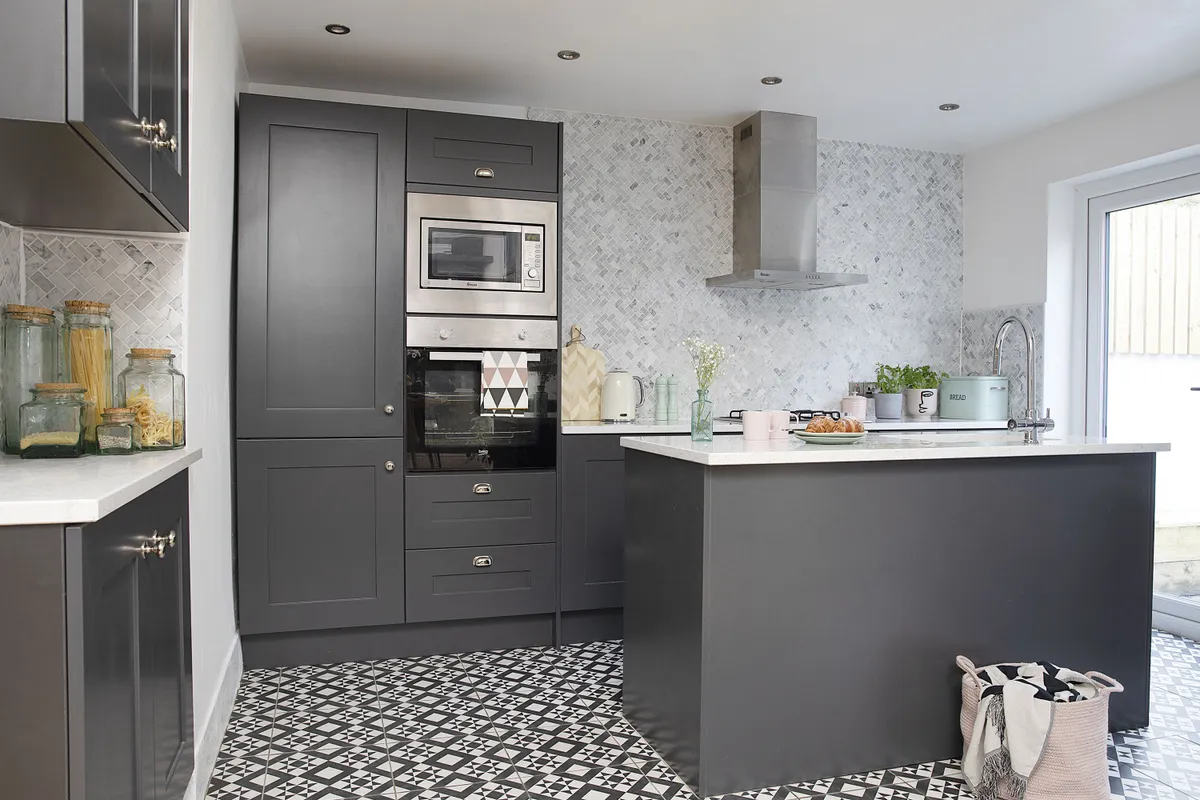 ‘I fell in love with these floor tiles from Porcelain Superstore. They work so well against the dark kitchen and the marble mosaic wall tiles from Walls and Floors. We got the oven and microwave separately from Very, and it looks so much better having the fridge-freezer hidden behind doors’
