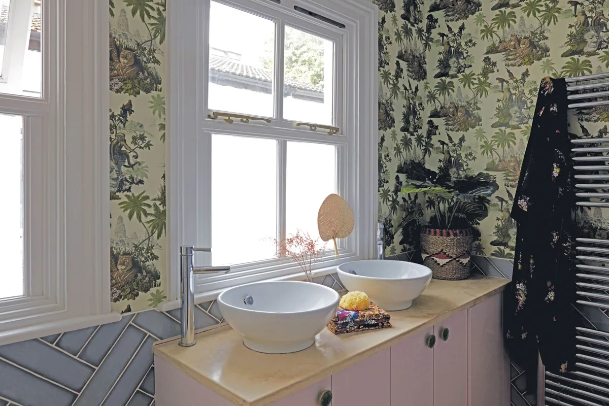 With blue tiles, a pink vanity unit and floral wallpaper, the bathroom, like the other rooms, is made up of what Natalie likes. ‘Nothing matches, but everything works together,’ she says
